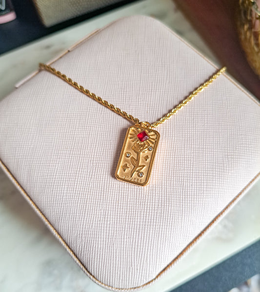 Vintage-style rose pendant with bold red gem on gold chain